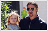 Photo editing example (before & after) of inserting a new element in a photo. A parrot has been added to Brad Pitt's family photo.