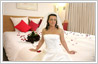 Photo editing services to change background in bride's photo to a well decorated bridal honeymoon suite decorated with flowers.