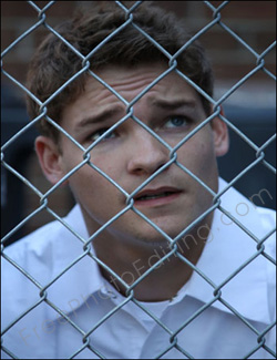 Photo editing required: This is a photograph of a prison inmate inside a jail compound, perhaps contemplating a breakout or simply yearning for freedom. The editing job is to remove the iron mesh that comes between him and the free world beyond.