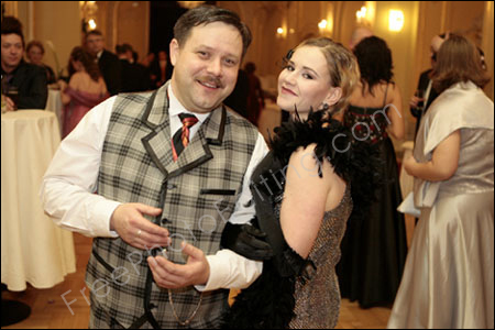 This is a photo of a couple at a party. The background needs to be blurred or faded so that the attention is focued on the couple. The photo after editing can be seen below.
