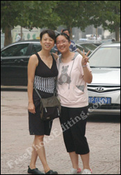 Photo editing required: These two Chinese girls want to be transported from this parking lot to the historical tourist site of Chichen Itza in Mexico