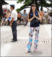 Photo editing required. This is a photo of a woman holidaying in Japan. The lady wants to be placed in the Kamakura temples photo on the right. She can be seen in a reverential posture, with folded hands -- palms facing each other. 