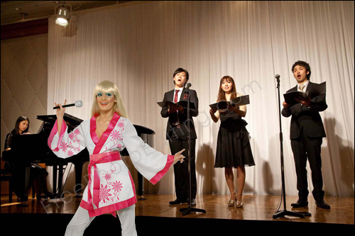 This is a photo editing example in which a singer's photo taken on white background needs to be placed on a stage where a recital is ongoing.
