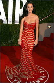 Photo editing is required to change backdrop in photo. Kate Perry is at the Vanity Fair Oscar party in a red mermaid dress. Kate Perry is to be extracted from this photo and placed against a seaside view. The resultant photo after editing can be seen below.
