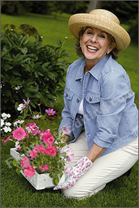 Before photo editing: This is a picture of a fashionable lady with a green thumb -- i.e. for whom gardening is a hobby that must be pursued in style. Note her nice straw hat (to keep the sun away), pretty gardening gloves and generally pleasing demeanor. The background of this photo has to be removed and the woman to be moved into the photo on left.