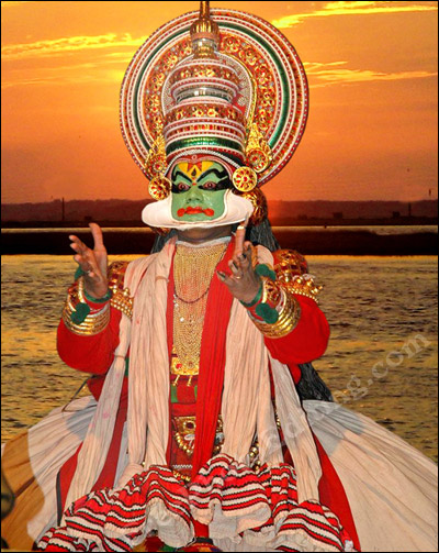 Kathakali dancer performing against a sunset sky