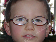 Eyeglass glare in little boy's glasses due to camera flash